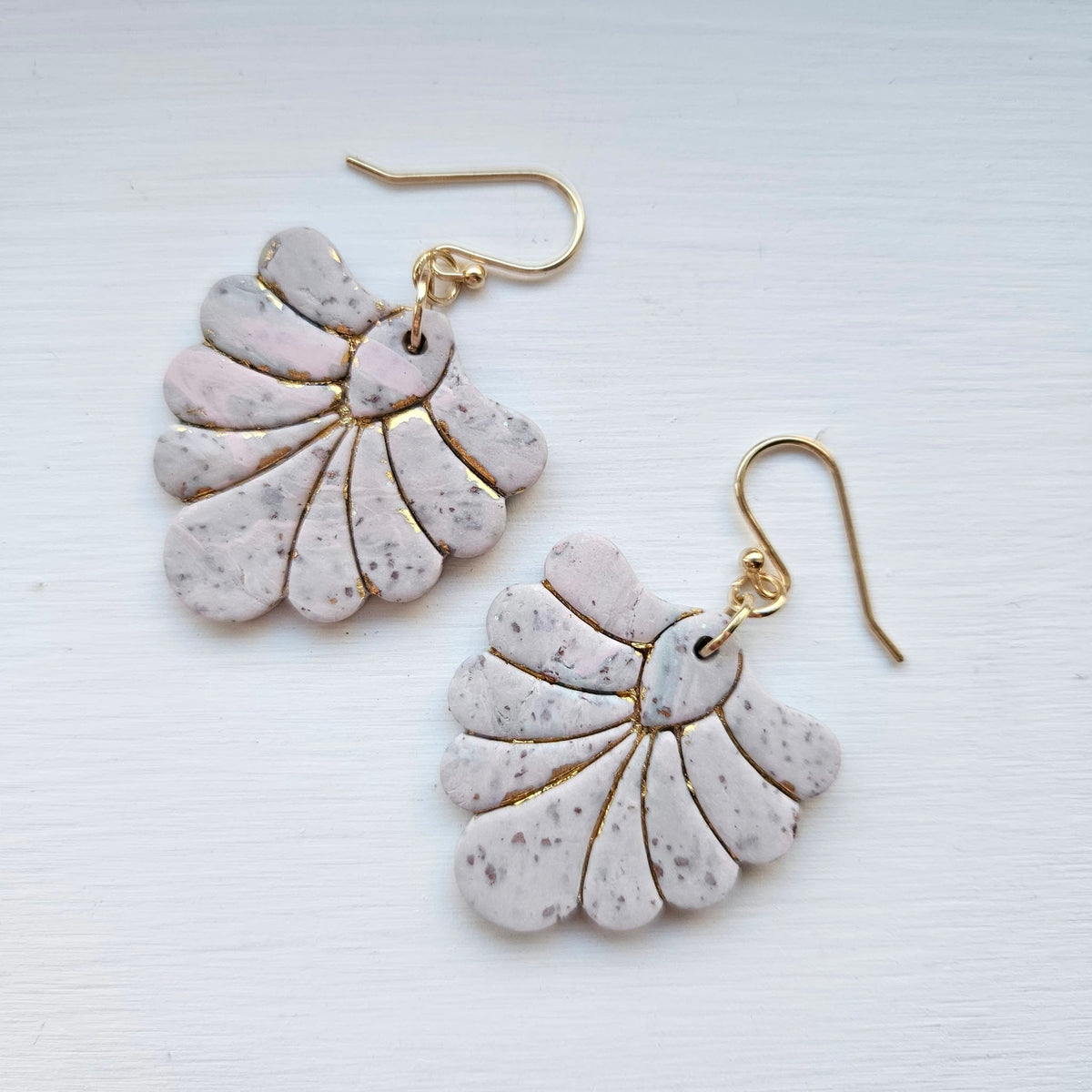Pair of blush pink and ivory fan-shaped polymer clay earrings with gold details and gold ear wires.