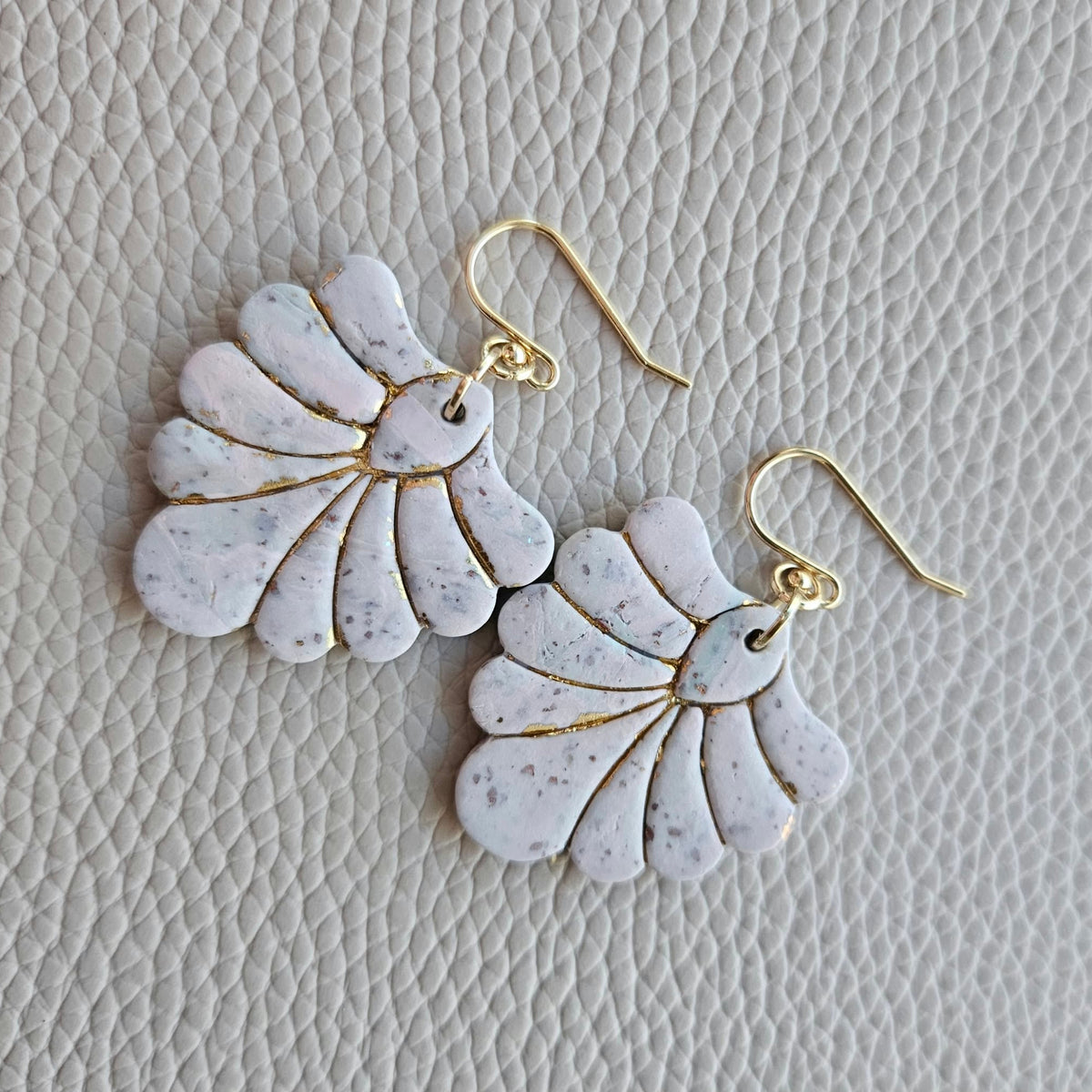 Pair of blush pink and ivory fan-shaped polymer clay earrings with gold details and gold ear wires.
