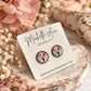 Antique bronze floral stud earrings with colourful pink wildflower artwork, displayed on a Michelle Ann Jewelry earring card with soft pink flowers.