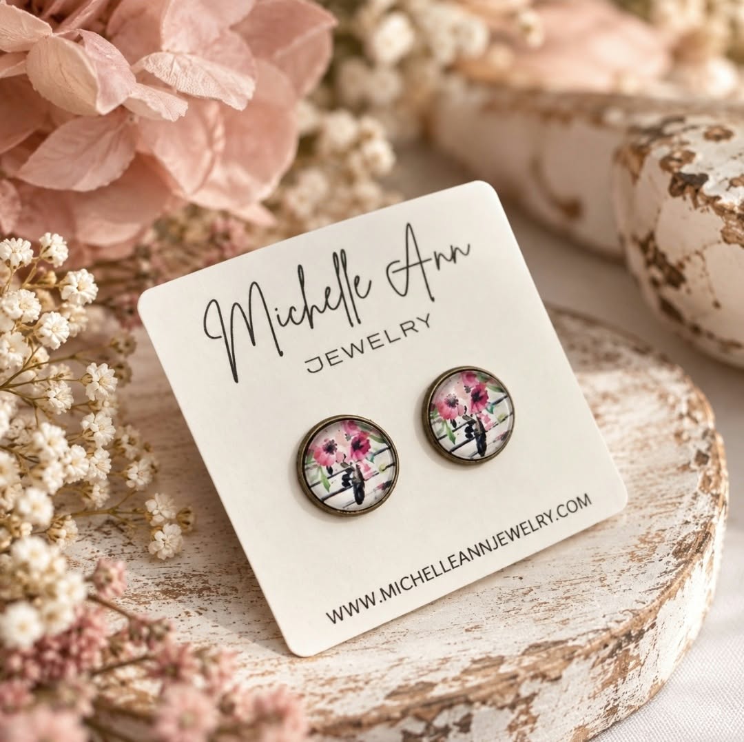Antique bronze floral stud earrings with colourful pink wildflower artwork, displayed on a Michelle Ann Jewelry earring card with soft pink flowers.