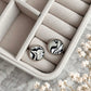 Black and white zebra print round stud earrings with resin domes and stainless steel settings, displayed inside a soft beige jewellery box.